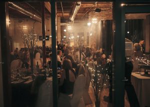 dinner is taking place with family and friends in an industrial setting. london ontario wedding photographer welsey forbes photography